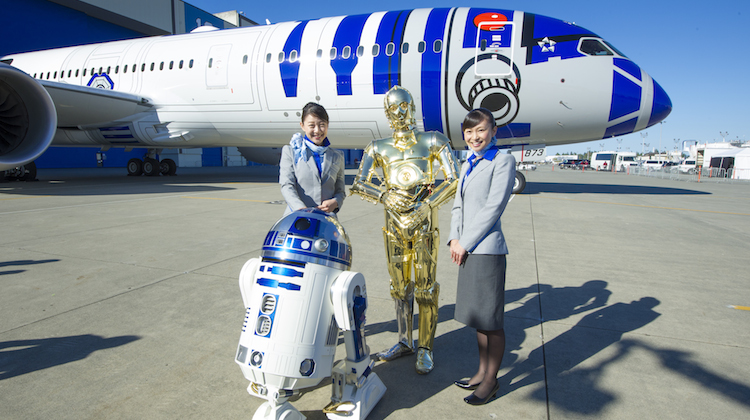 ANA staff with Star Wars characters and the 787-9 R2-D2 themed Dreamliner in the background. (ANA/Boeing)