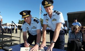 Outgoing and incoming Commander Air Lift Group AIRCDRE Gary Martin and AIRCDRE Warren McDonald sign the Change of Command certificates. (Defence)