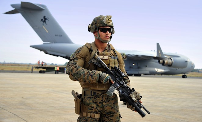 A US Marine keeps watch while A41-208 is unloaded on the ground in Juba, South Sudan. (Defence)