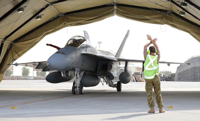 A RAAF Super Hornet is marhalled into its hangar.