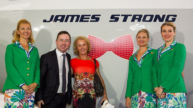 Jeane-Claude Strong with Alan Joyce and Qantas crew in front of a bowtie decal on VH-XZP's nose in James Strong's honour. (Seth Jaworski)