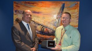 Thomas Global Systems director for customer service Gerald Timmermans presenting the LCD avionics display unit to Rex continuing airworthiness manager Richard Taylor. (Rex)