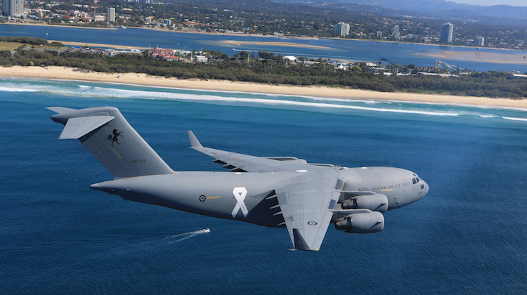 A C-17 with a white ribbon on the fuselage on its flypast. (Defence)