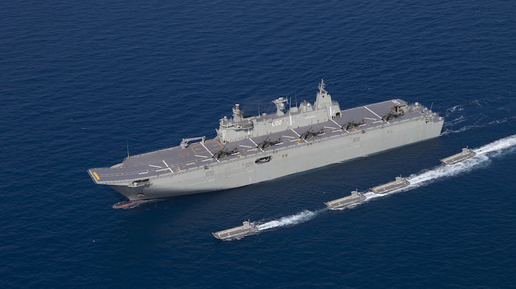 HMAS Canberra off the north Queensland coast with 5 MRH 90 aircraft on deck and her four Landing Craft deployed. (Defence) 