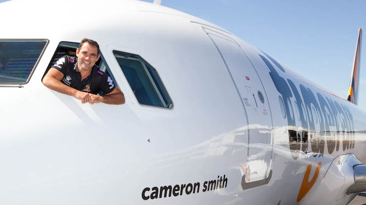 Melbourne Storm captain Cameron Smith in the flight deck of Tigerair Australia Airbus A320 VH-XUH with his name on the fuselage. (Tigerair Australia)