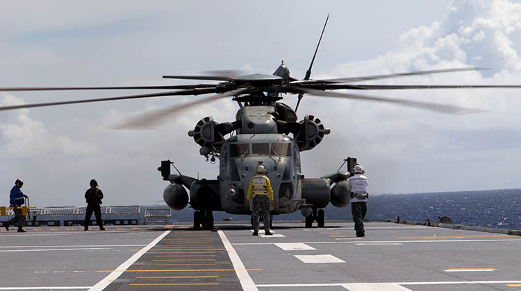 Aviation Support sailors move in to chock and chain a United States Marine Corps CH-53E Super Stallion helicopter on the flight deck of HMAS Canberra off the coast of Hawaii during Exercise Rim of the Pacific (RIMPAC) 2016.