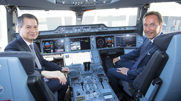 Thai Airways president Charamporn Jotikasthira and Airbus chief executive Fabrice Bregier pose in the flight deck of the airline's first A350. (Airbus) 