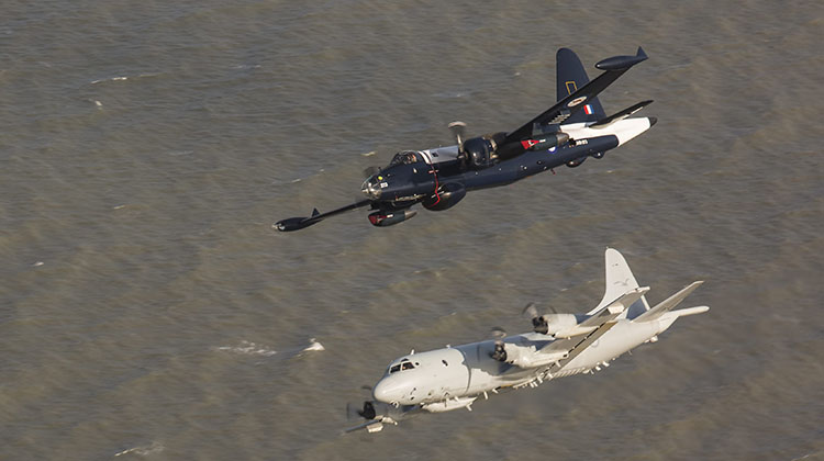 A Lockheed Neptune maritime patrol aircraft and an AP-3C Orion aircraft participate in a flypast during the T150 Townsville Defence Force Air Show.