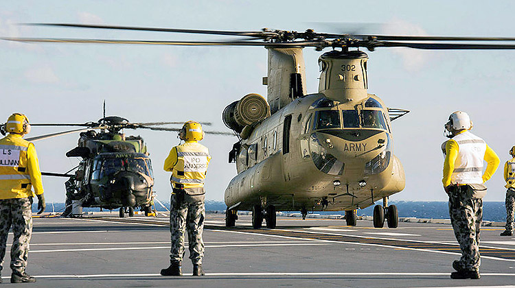 An Army MRH90 (background) and CH-47F (foreground) onboard HMAS Adelaide, as part of first of class flight trials in August 2016. (Defence)