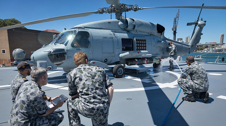 Members of the Aircraft Maintenance and Flight Trials Unit prepare to traverse a MH-60R Seahawk Helicopter onboard HMAS Hobart during flight deck trials conducted alongside Fleet Base East, Garden Island, Sydney. (Defence)