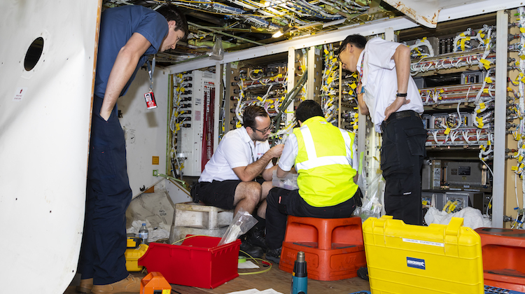Virgin Australia staff working in the electronics bay of one of the airline's Boeing 777-300ERs. (Seth Jaworski)