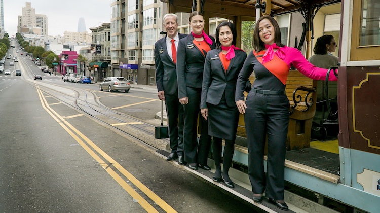Qantas cabin crew hanging off a San Francisco trolley. (Qantas)