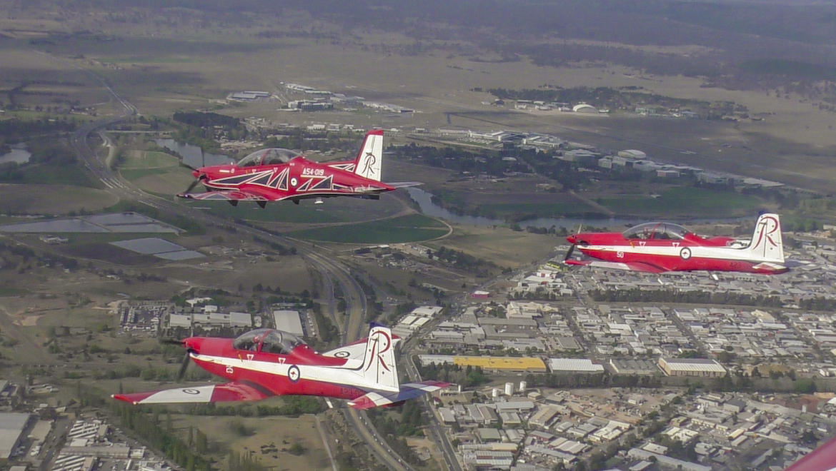 Two RAAF PC-9 aircraft trail a new PC-21 aircraft, over Parliament House in Canberra. (Mark Jessop)