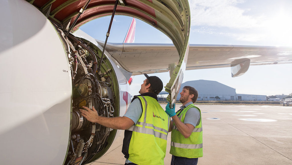 Engineers inspect an aircraft engine.