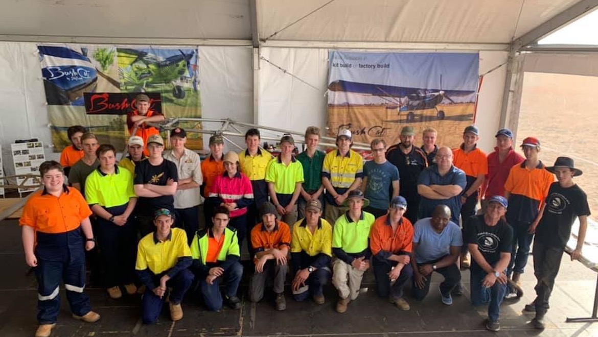 The 25 students who were part of the BushCat seven-day build pose for a photograph at the AirVenture Australia airshow alongside their supervisors. (Marena Janse van Rensburg)