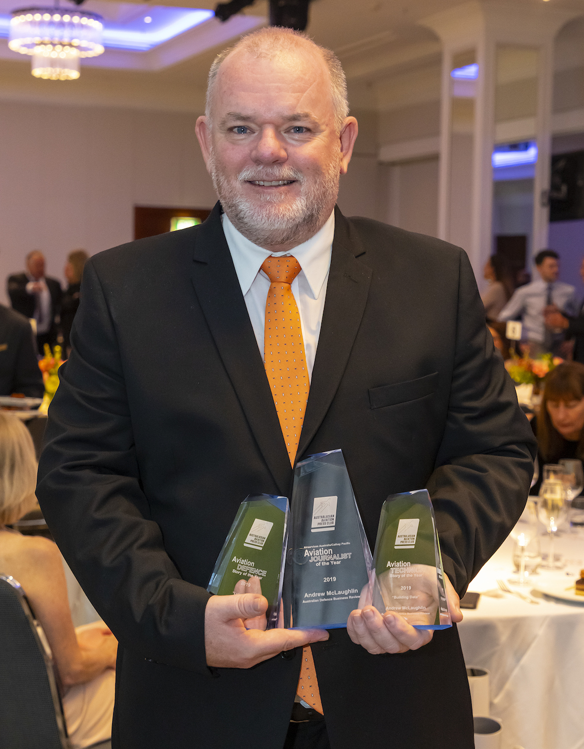ADBR managing editor Andrew McLaughlin with his three AAPC awards. (Seth Jaworski)