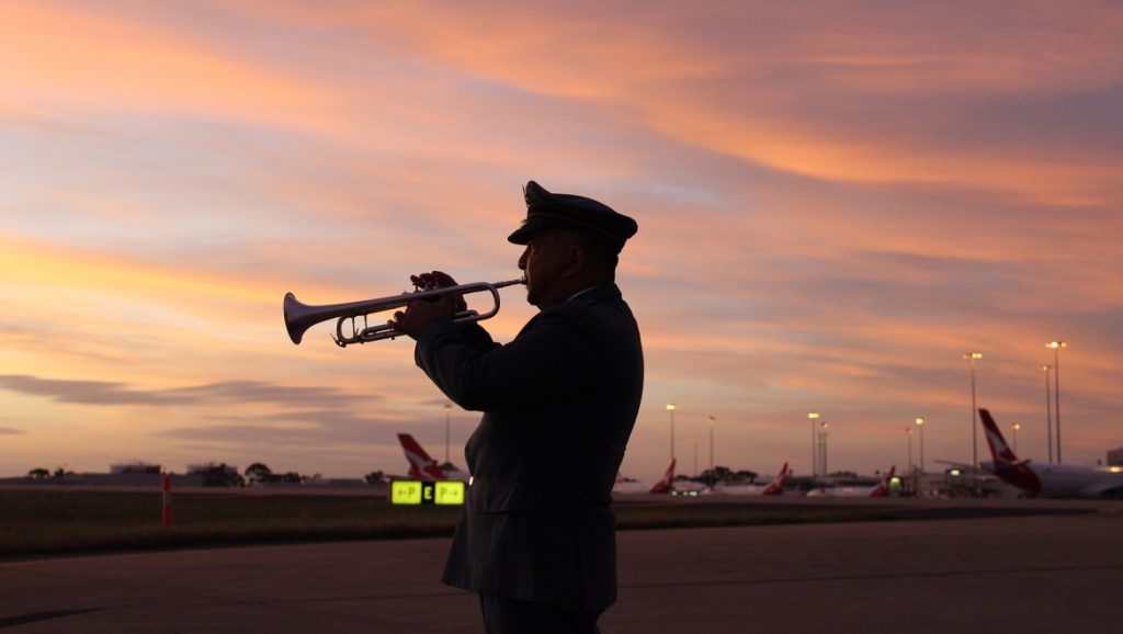 Melbourne Airport_Allan Hessey_RSLbugler_playing the Last Post with sunrise in the background 2